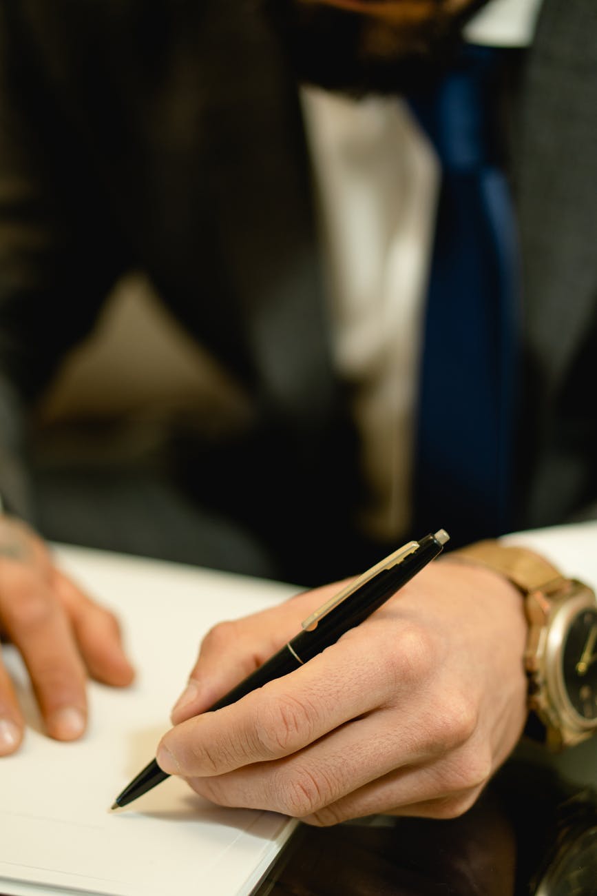 close up photo of a person s hand signing a paper